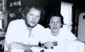 Brothers breakfasting at the oak table.